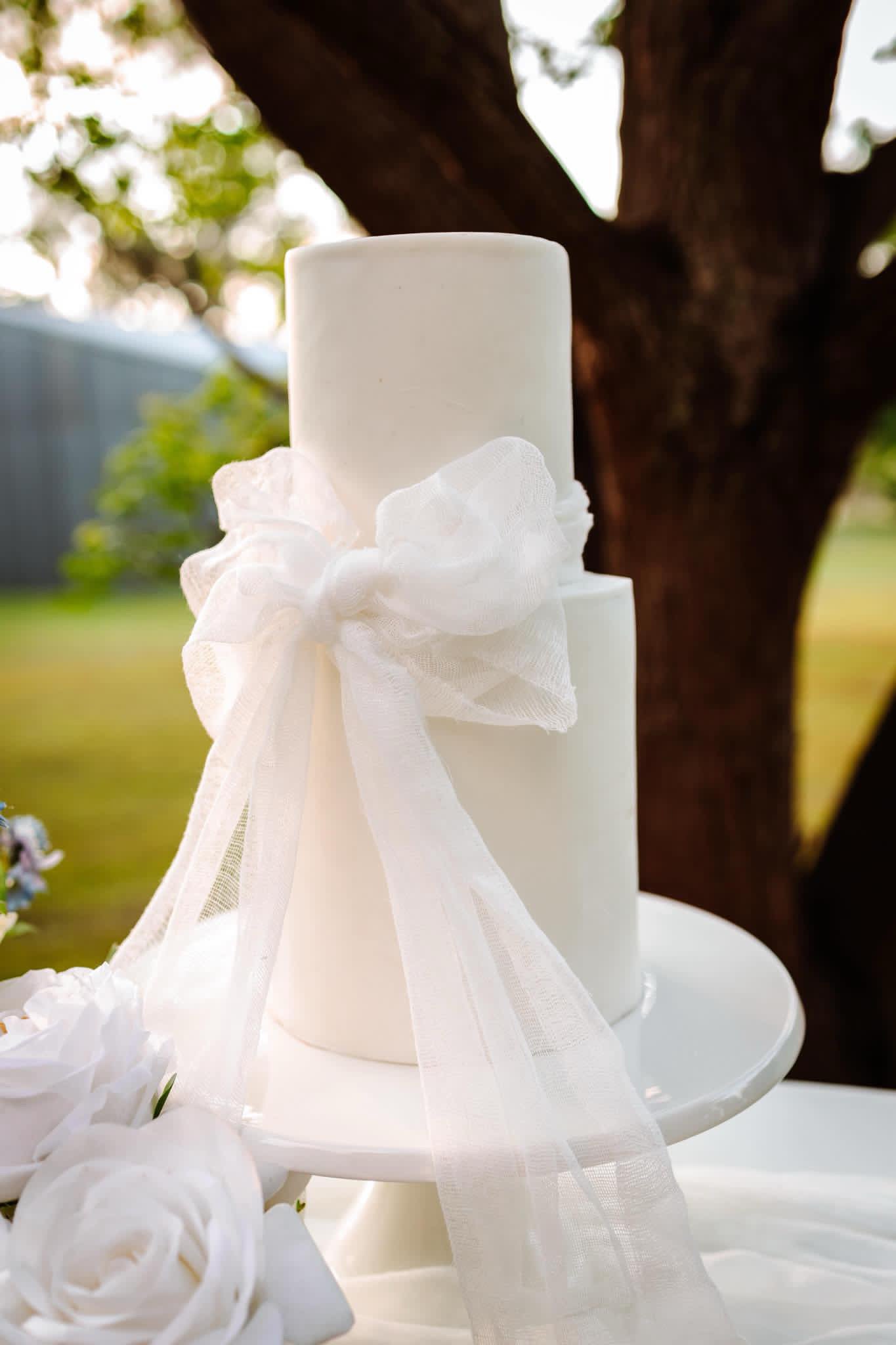 Two tier white wedding cake with tulle bow
